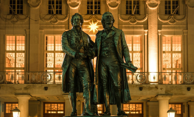 Goethe- und Schillerdenkmal vor beleuchtetem Theater in Weimar    