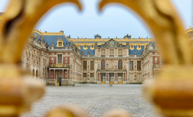 Blick durch die goldenen Tore auf den Eingangsbereich des Schloss Versailles bei Paris