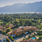 Luftaufnahme des Hotel Giardino Ascona mit Gebäuden, Park und Lago Maggiore