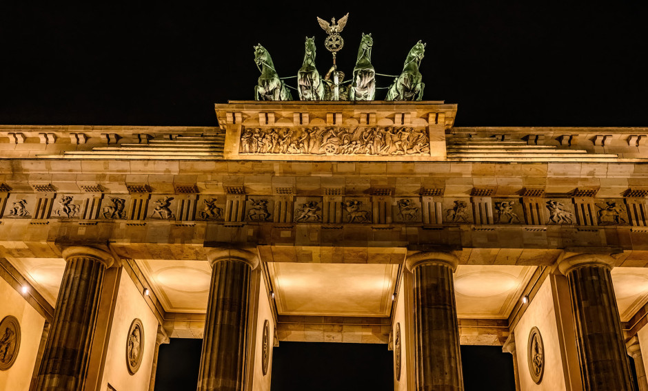 Blick auf das nächtlich beleuchtete Brandenburger Tor in Berlin