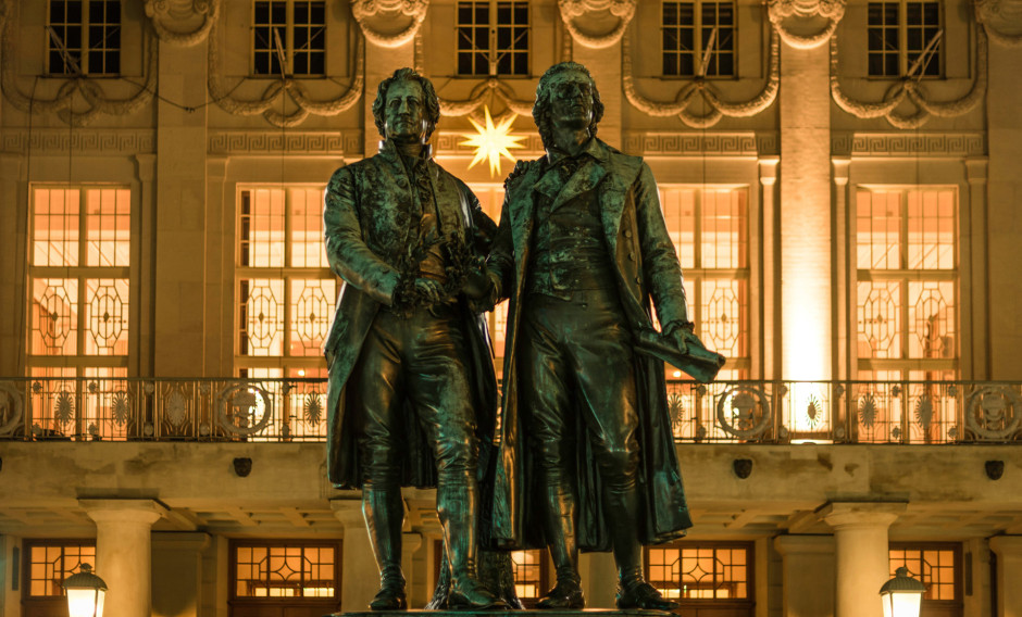 Goethe- und Schillerdenkmal vor beleuchtetem Theater in Weimar
